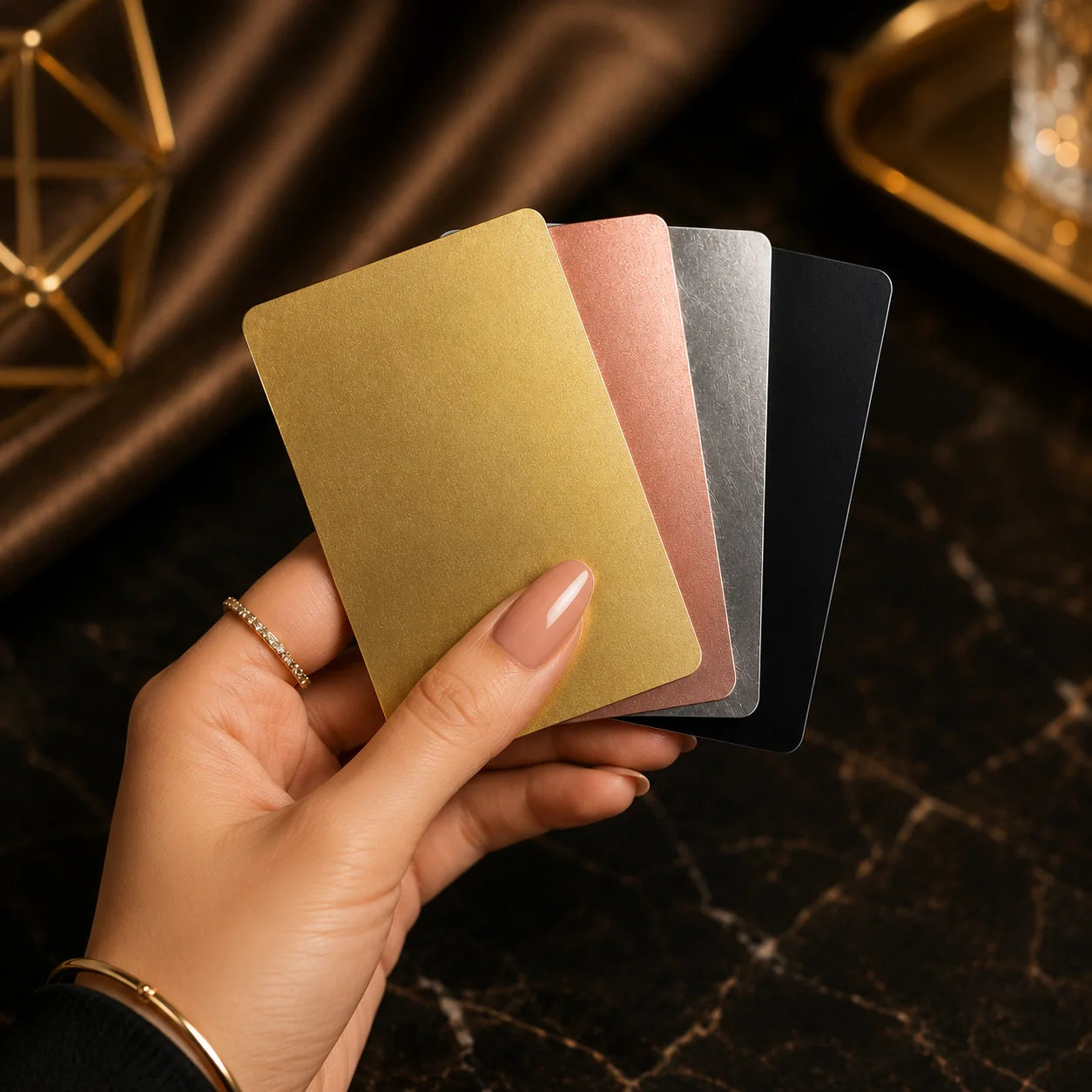 Women Hand holding golden, reose gold, silver & black metal card in preimum background FreeLink