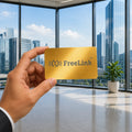 Hand holding a gold NFC Metal card with 'FreeLink' logo in an office setting